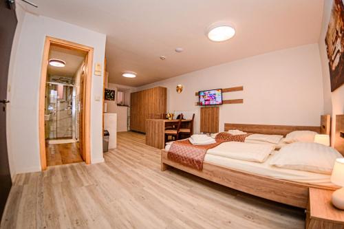 a bedroom with a large bed and a desk at Hotel Kaskada in Poprad