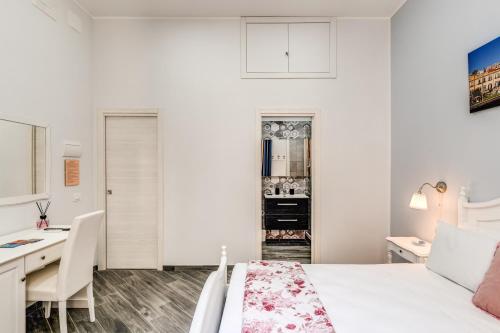 a white bedroom with a desk and a bed at Agorà Borsa in Naples