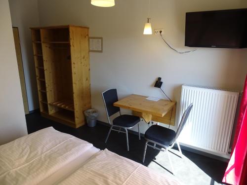 a bedroom with a desk and a bed and a table and chairs at Hotel Demling in Randersacker