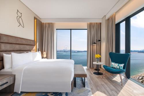 杜拜的住宿－voco Dubai The Palm, an IHG Hotel，配有一张床、一张书桌和一扇窗户的酒店客房