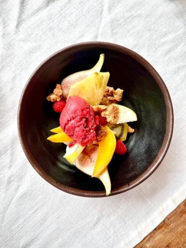 a bowl of food with fruit on a table at Logis Hôtel La Fenière in La Bouilladisse