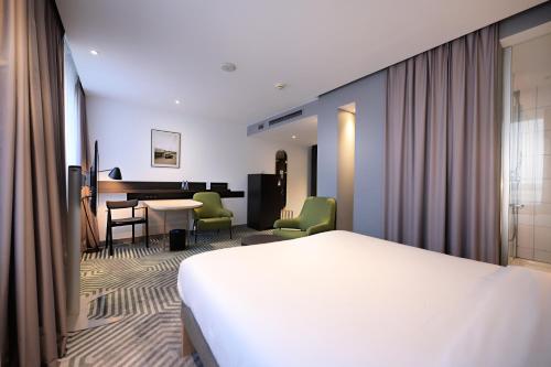 a hotel room with a bed and a table and chairs at Mercure Warszawa Grand in Warsaw