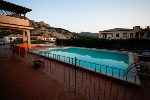 a swimming pool with a fence next to a house at Domus Smeralda B&B in Porto Cervo