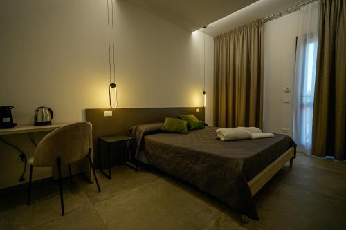 Domus Smeralda B&B في بورتو كيرفو: غرفة نوم بسرير ومكتب وطاولة