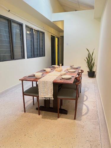 a dining room table with bowls and plates on it at V Lodge in Kuantan