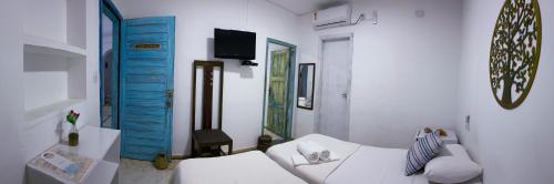 a living room with a white couch and blue doors at Casarão Jeri in Jericoacoara