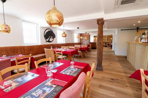 Black Forest Hotel Kappel-Grafenhausen في كابل غرافنهاوسن: غرفة طعام مع طاولات وكراسي حمراء