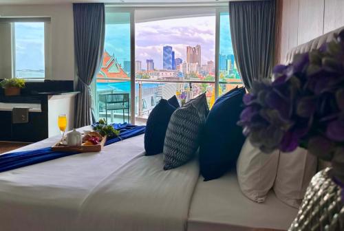 a bedroom with a bed with a view of the city at Harmony Phnom Penh Hotel in Phnom Penh