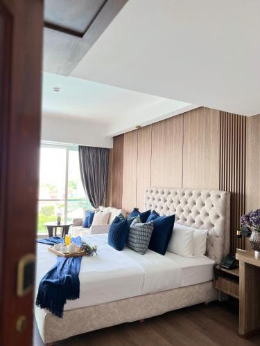 a bedroom with a large bed with blue and white pillows at Harmony Phnom Penh Hotel in Phnom Penh
