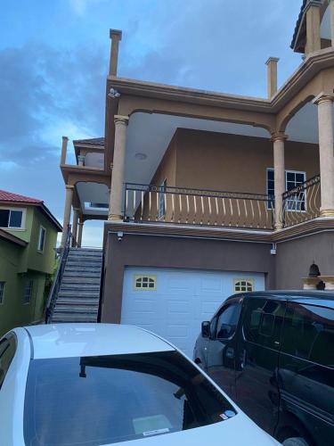 a white car parked in front of a house at paradise cove in Spanish Town