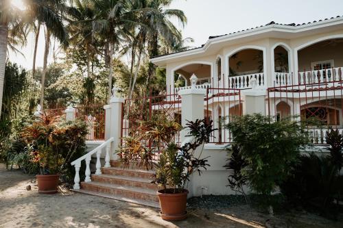 a white house with stairs and palm trees at Wiona of Villa Paraiso / Beachfront Villa & Pool in Big Creek