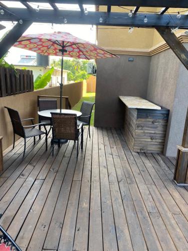 a patio with a table and chairs and an umbrella at paradise cove in Spanish Town