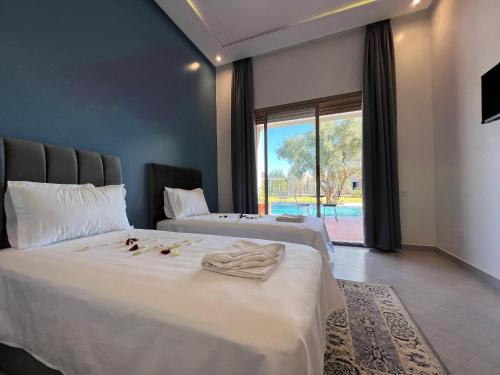 1 dormitorio con 2 camas y ventana grande en Dar Fatima Tamazouzt, en Marrakech