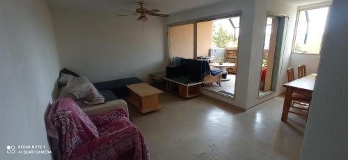 ein Wohnzimmer mit einem Sofa, einem Stuhl und einem Tisch in der Unterkunft Appartement T3 in Valbonne