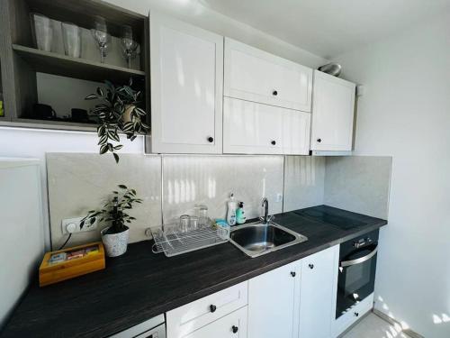 a kitchen with white cabinets and a sink at Classic Modern Apartment with Parking Place in Sofia