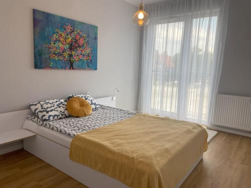 a bedroom with a bed and a painting on the wall at Wygodne Mieszkania Nova Mikołowska 135 in Katowice