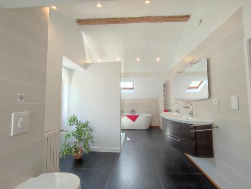 La salle de bains est pourvue de toilettes, d'un lavabo et d'une baignoire. dans l'établissement Château du Pommoy, à Roussillon-en-Morvan