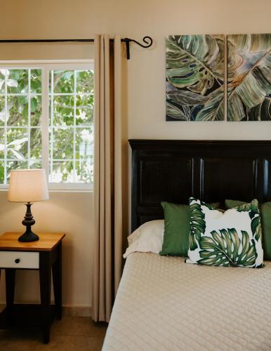 a bedroom with a bed with green pillows and a window at Wiona of Villa Paraiso / Beachfront Villa & Pool in Big Creek