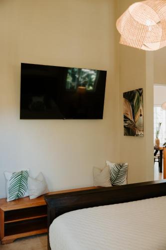 a bedroom with a bed and a flat screen tv on the wall at Wiona of Villa Paraiso / Beachfront Villa & Pool in Big Creek