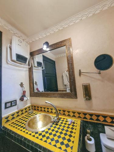 un baño con lavabo y espejo en Riad Jaime, en Marrakech
