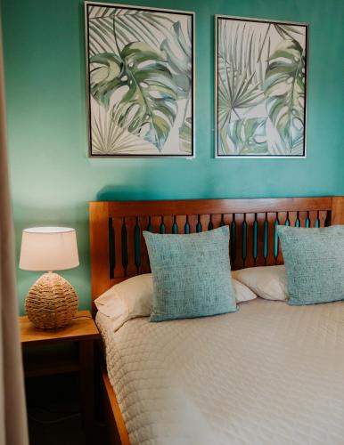 a bedroom with a bed with two pictures on the wall at Wiona of Villa Paraiso / Beachfront Villa & Pool in Big Creek