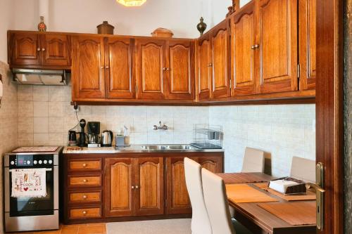 uma cozinha com armários de madeira e uma mesa de madeira em Μονοκατοικία με θέα τη Χώρα em Skiros