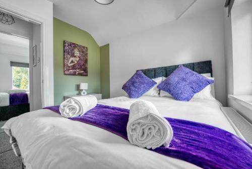 a bedroom with a large bed with purple sheets and pillows at Team Accomodation 4 Bedroom Free Parking WiFi Moseley Birmingham near City Centre NEC BHX in Birmingham