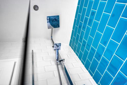 伯明罕的住宿－Team Accomodation 4 Bedroom Free Parking WiFi Moseley Birmingham near City Centre NEC BHX，浴室的墙壁上铺有蓝色和白色的瓷砖。