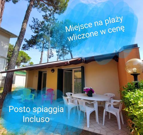 ein Haus mit einem Tisch und Stühlen davor in der Unterkunft Villette Susanna in Lignano Sabbiadoro