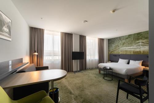 a hotel room with a bed and a desk at Mercure Warszawa Grand in Warsaw