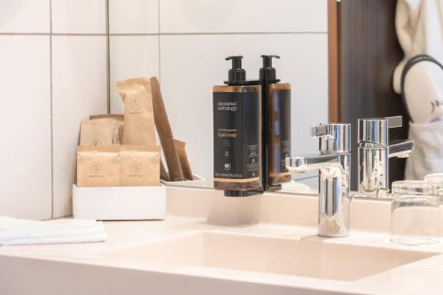 a bathroom sink with two bottles of hair products on it at Mercure Warszawa Grand in Warsaw