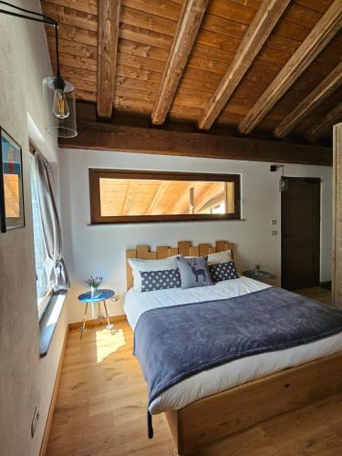 a bedroom with a large bed in a room with wooden ceilings at Ai Tetti Nuovi in Roccaforte Mondovì
