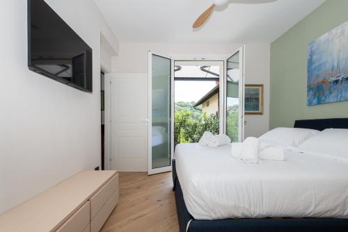 1 Schlafzimmer mit 2 Betten und einem großen Fenster in der Unterkunft MG House Luxury in Como