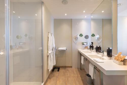 a bathroom with two sinks and a shower at Mercure Warszawa Grand in Warsaw