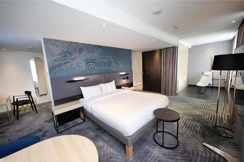a hotel room with a large white bed and a table at Mercure Warszawa Grand in Warsaw