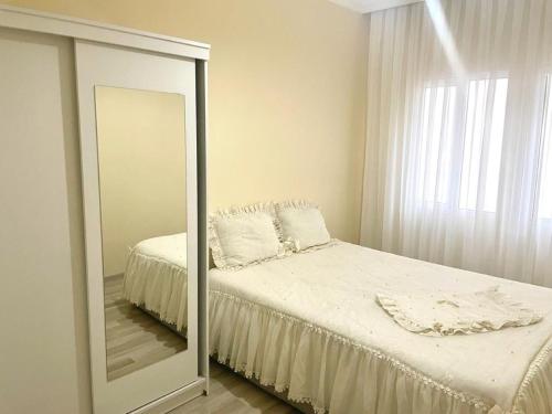 a mirror in a bedroom with a bed and a mirror at Çeşme Merkezde Marinaya 5 Dakika in Cesme