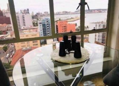 a glass table with a view of a city from a window at Elegant Durban Harbor View Bnb in Durban