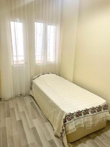 a bed in a room with two windows at Çeşme Merkezde Marinaya 5 Dakika in Cesme