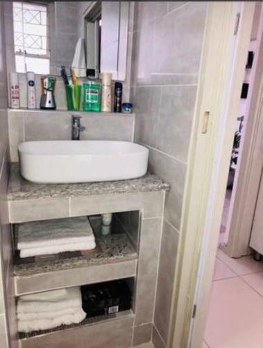 a bathroom with a white sink and towels at Elegant Durban Harbor View Bnb in Durban