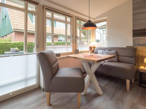 a living room with a table and a couch at Inselsünn Hotel und Apartments in Spiekeroog