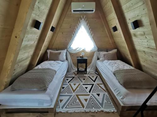 two beds in the attic of a tiny house at Stone Chalets LUNA in Jajce