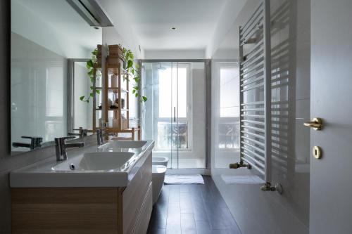 een badkamer met een wastafel, een toilet en een spiegel bij Moscova Cosy Apartment in Milaan