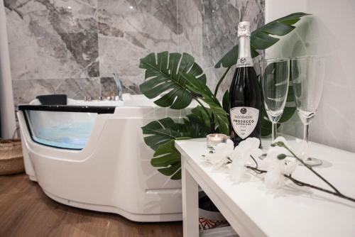 eine Flasche Wein auf einem Tisch neben einem Klavier in der Unterkunft AGF Luxury Apartment in Catania