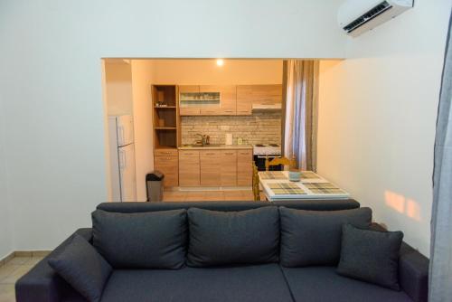 uma sala de estar com um sofá e uma cozinha em Sunset House em Kanallaki