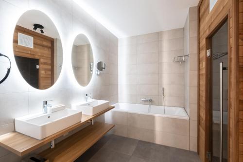 a bathroom with two sinks and a tub at Soal Beach Resort in Workum