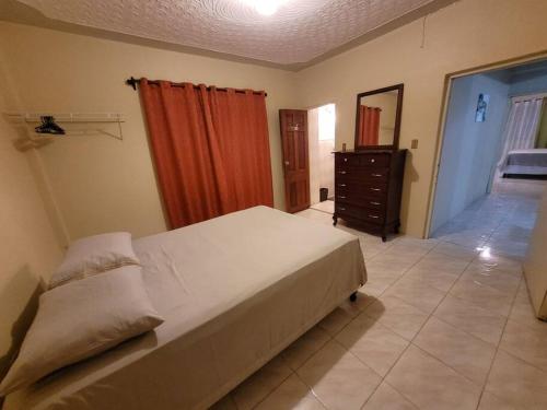 1 dormitorio con 1 cama blanca grande y vestidor en Serenity Heights, en Ewarton