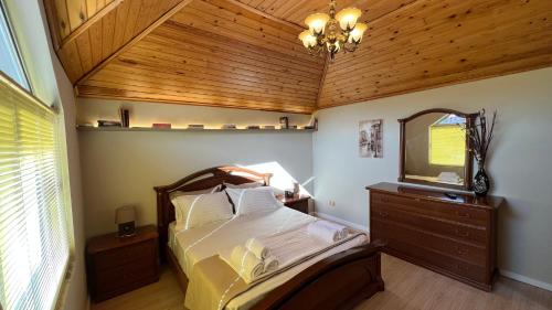 une chambre avec un lit avec un plafond en bois dans l'établissement Ora Apartment, à Shkodër