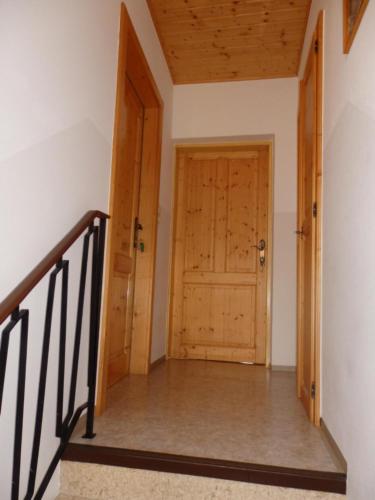 a hallway with a wooden door and stairs at Apartments Haus Steinbock in Tauplitz