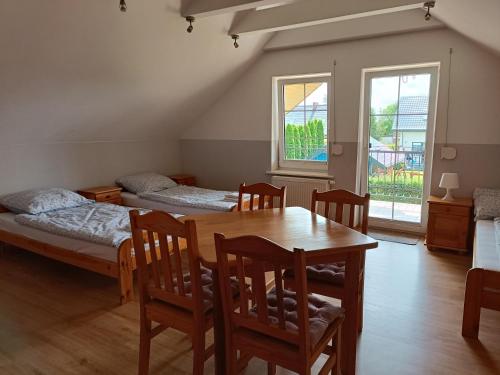 Pokój z 2 łóżkami, stołem i krzesłami w obiekcie Pokoje gościnne Weronika w mieście Puck