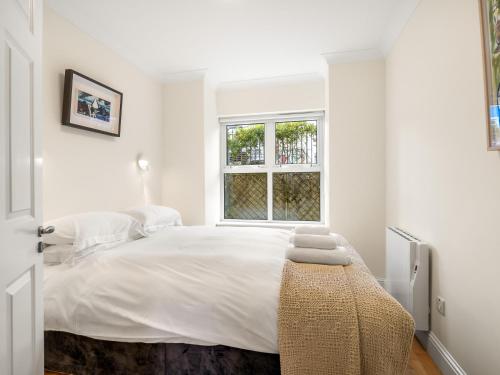 Un dormitorio blanco con una cama grande y una ventana en Stunning apartment Clifden en Clifden